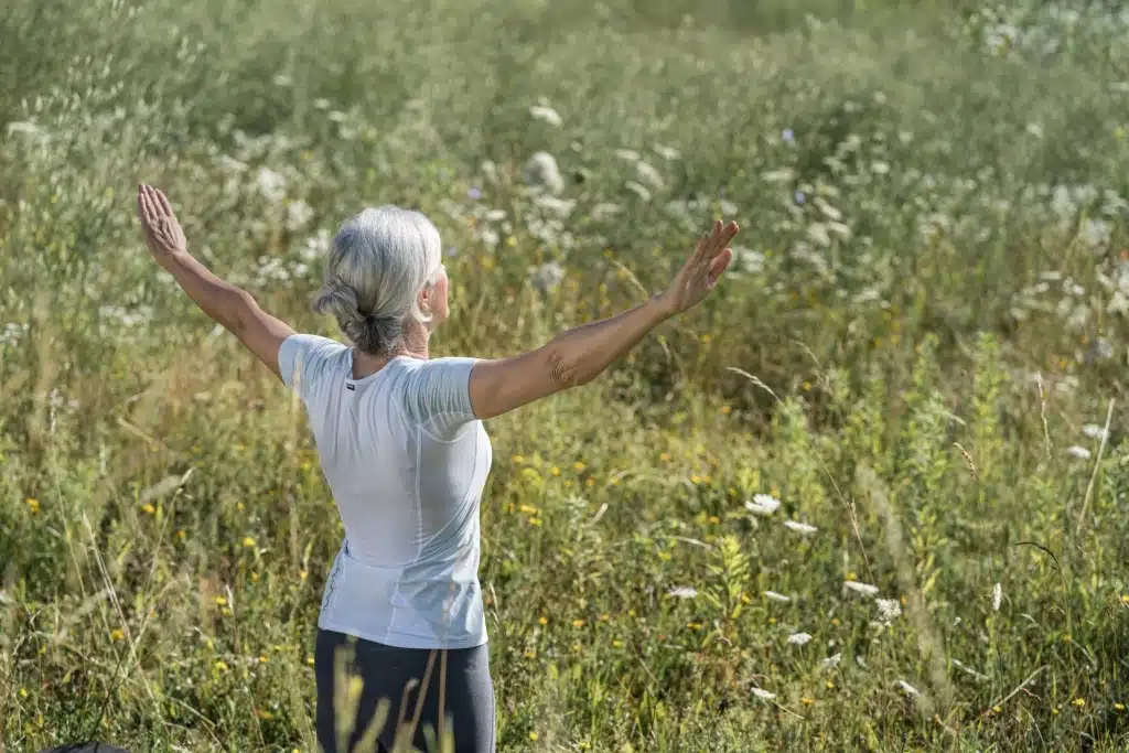 Frau macht den Sonnengruß in der Natur