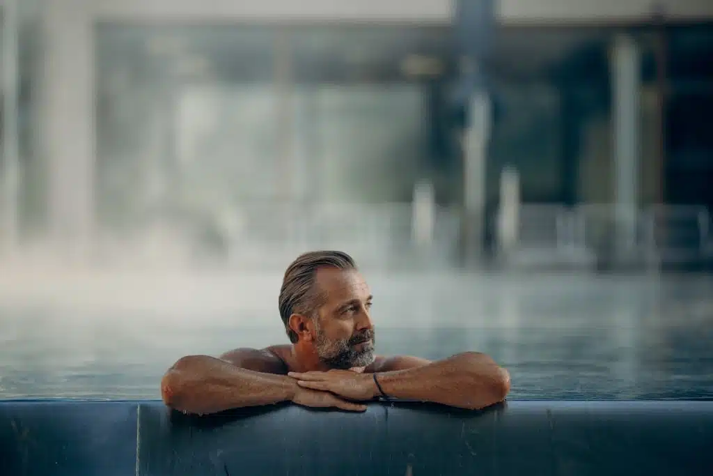 Mann im Wasser am Poolrand