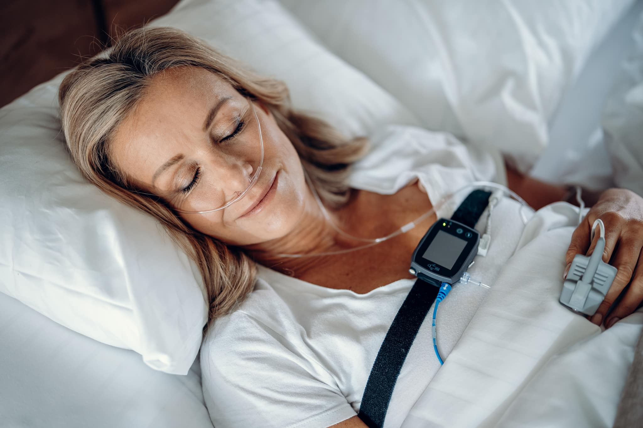 Frau im Bett für die Diagnostik mit dem mobilen Schlaflabor
