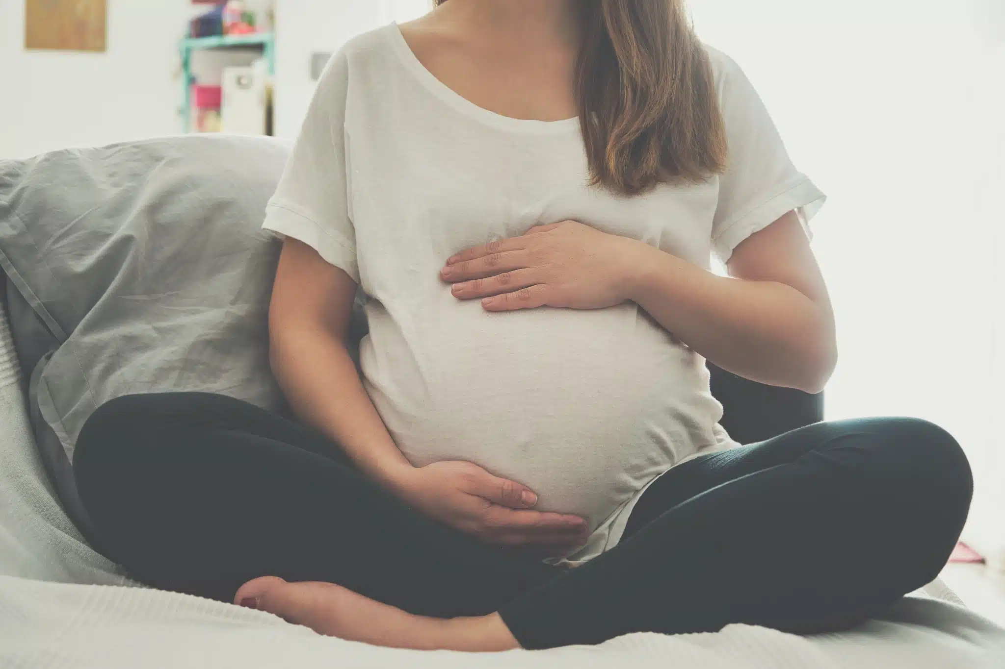 Schwangere Frau berührt ihren Babybauch